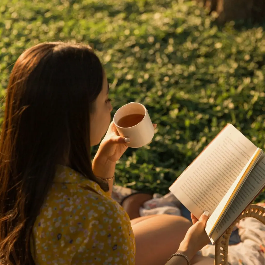 A cozy balcony garden with a chair, a book, and a cup of tea