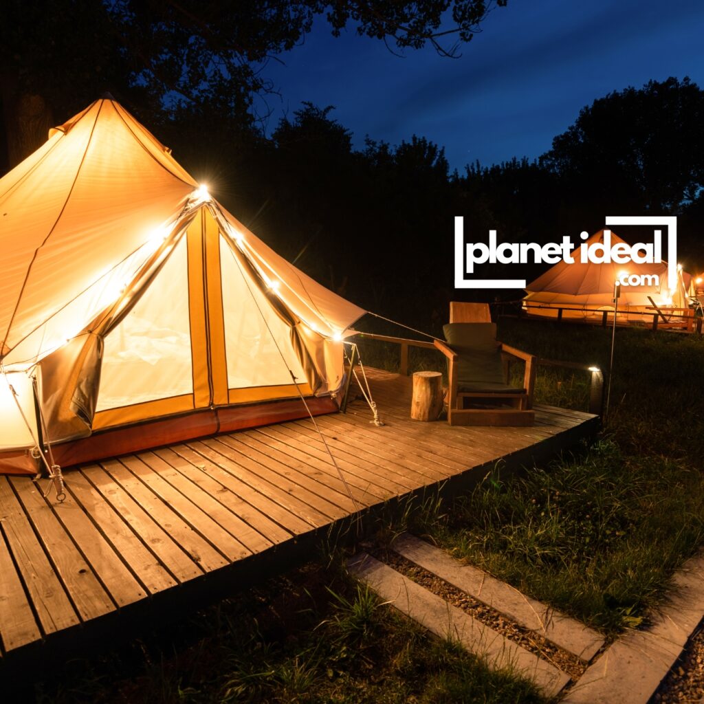 A cozy glamping tent with solar-powered lanterns, surrounded by forest or open fields.
