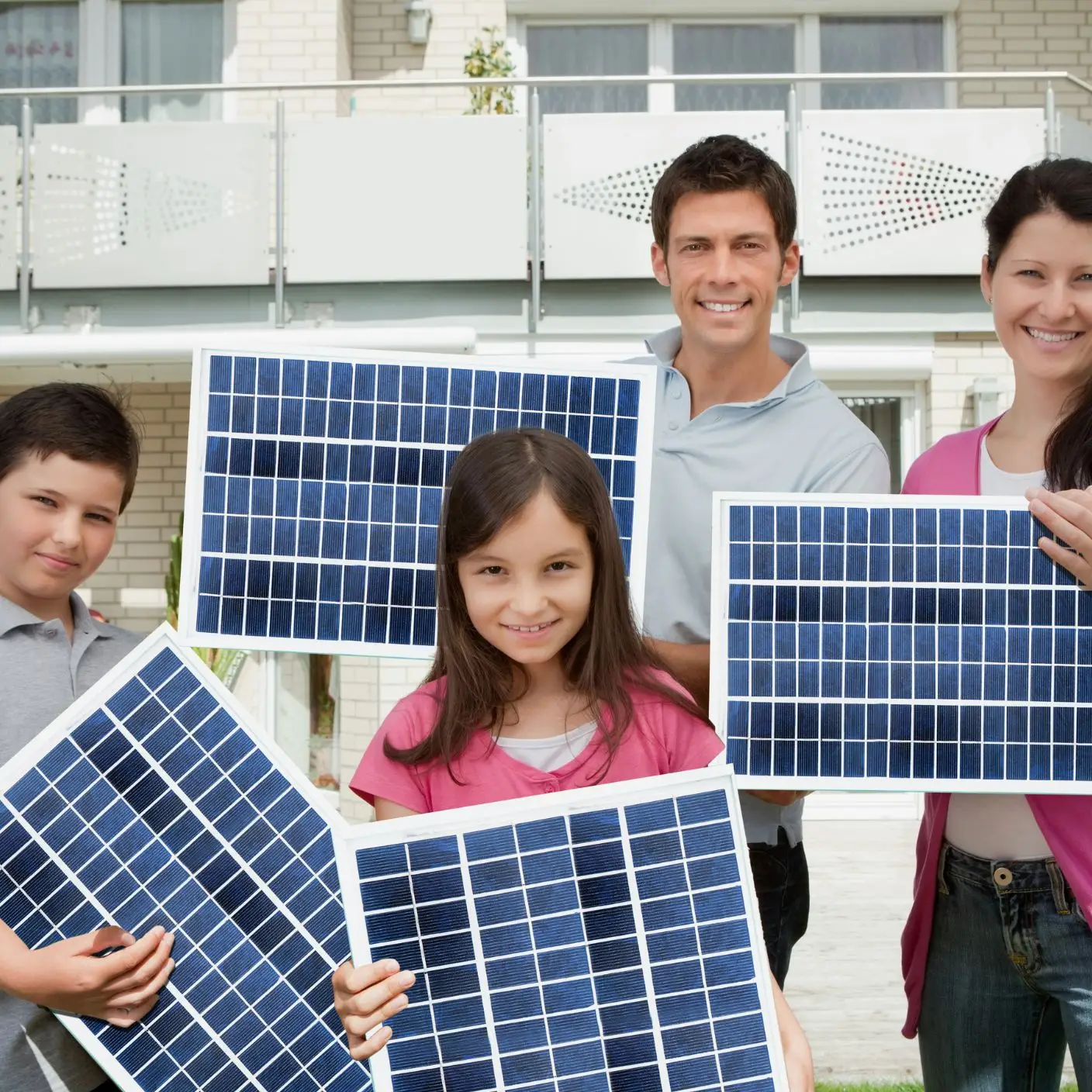 A happy family standing next to their solar-equipped home, symbolizing successful adoption despite challenges