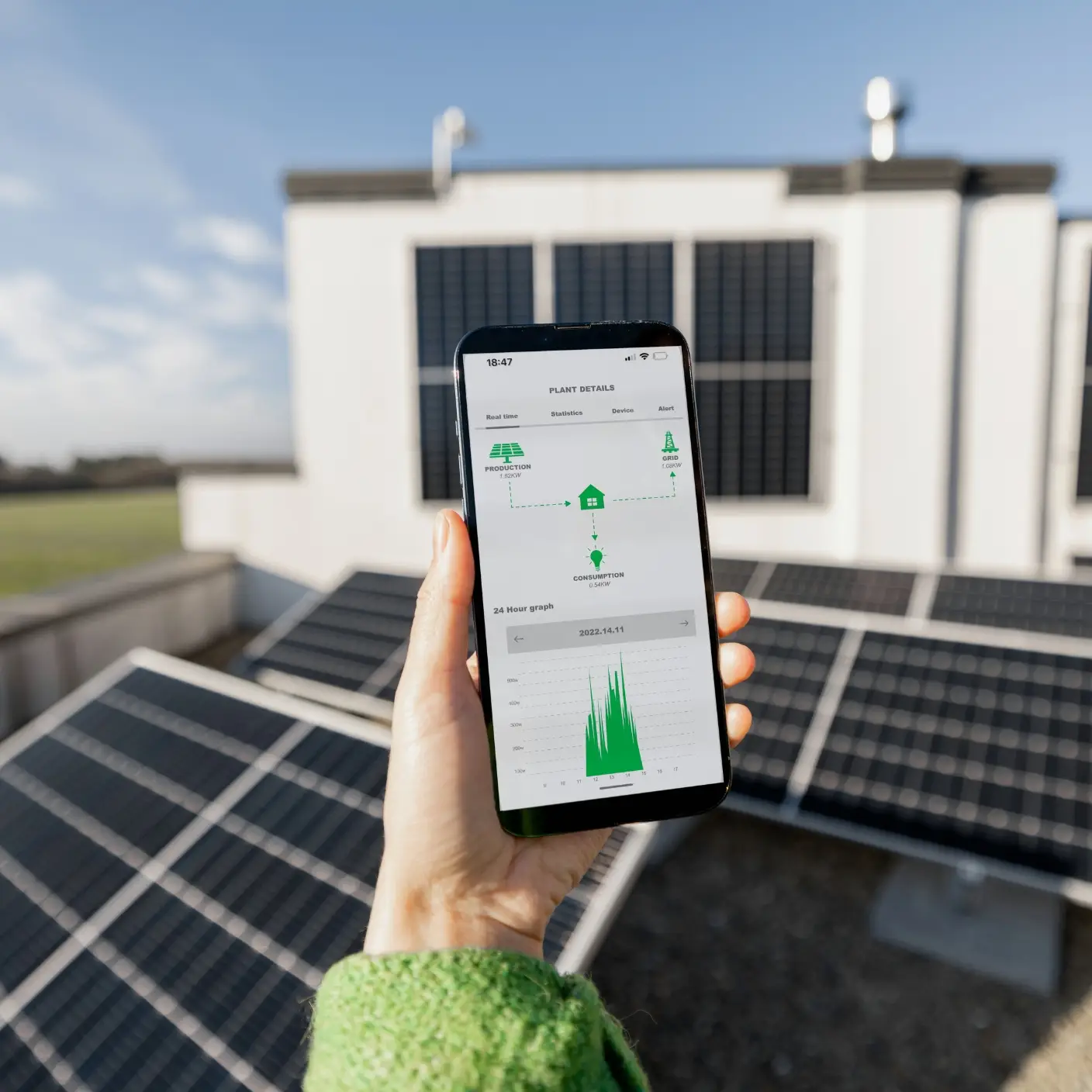 A homeowner using a smartphone app to monitor their solar energy production and usage.