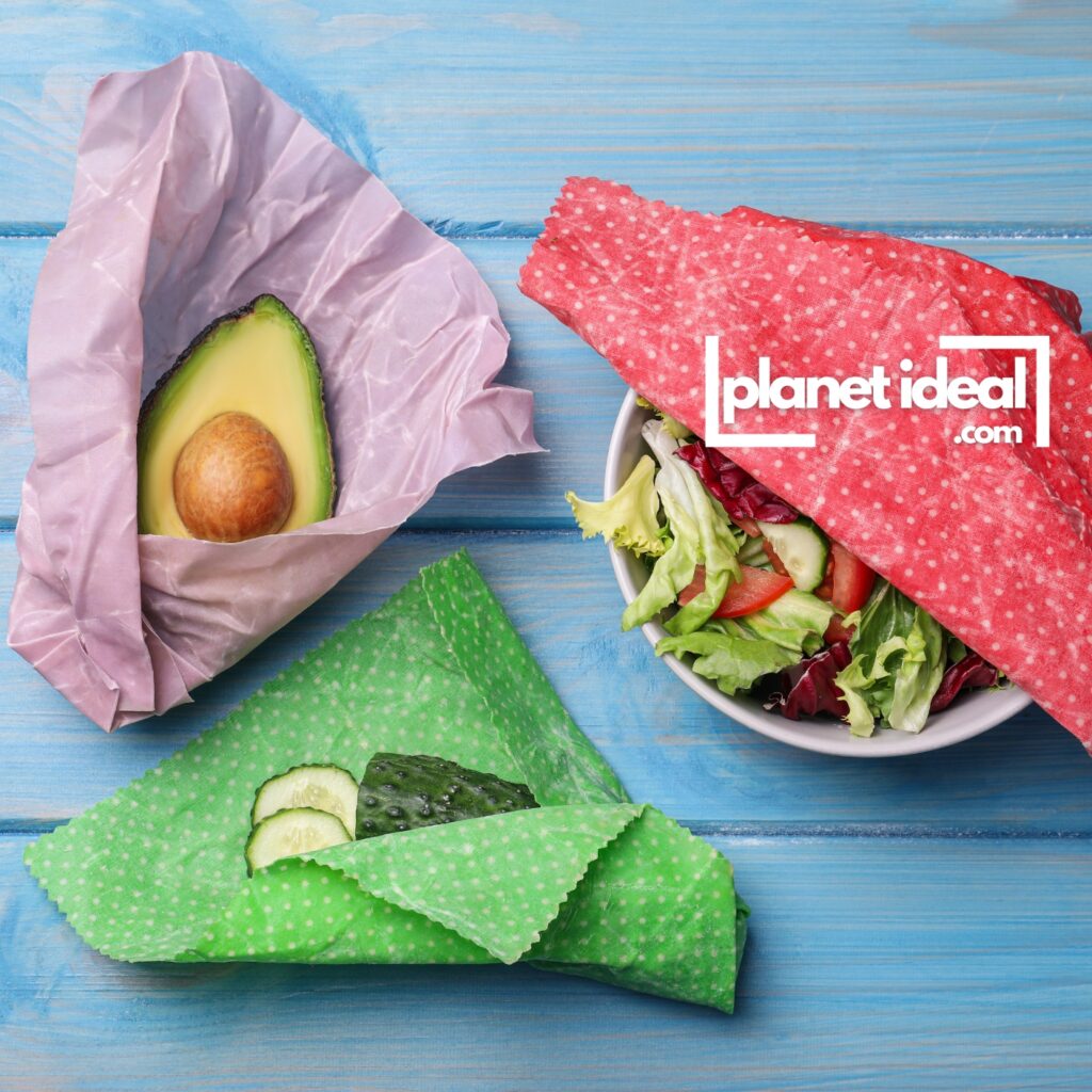 A kitchen counter with colorful beeswax wraps covering bowls and wrapping fresh vegetables.