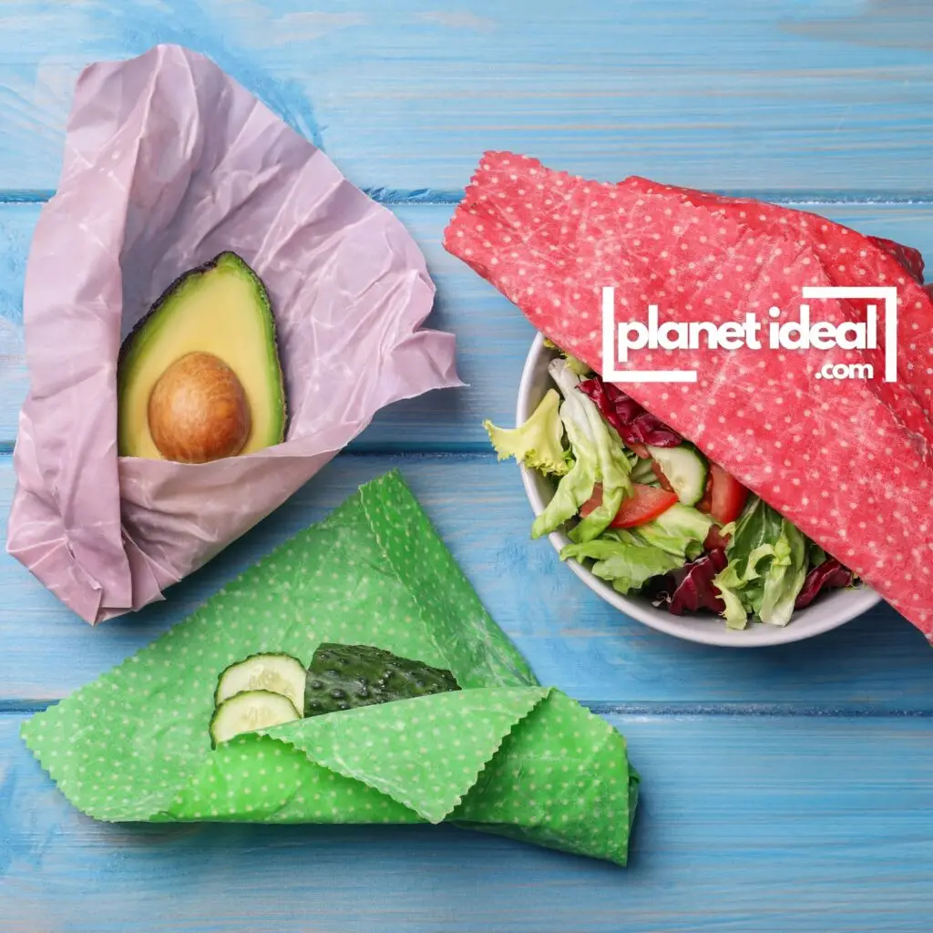 A kitchen counter with colorful beeswax wraps covering bowls and wrapping fresh vegetables.