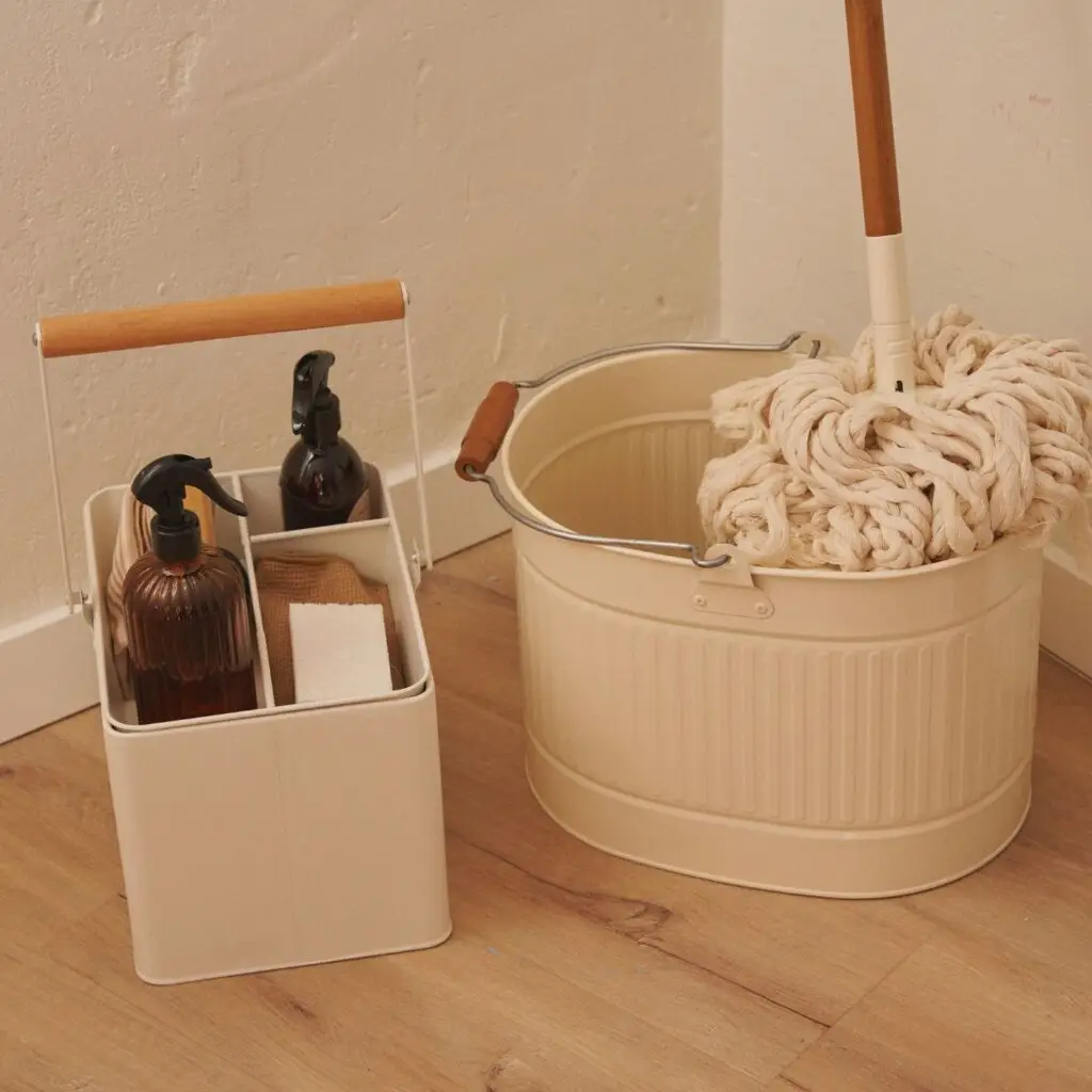 A minimalist cleaning caddy filled with eco-friendly spray bottles and reusable cloths