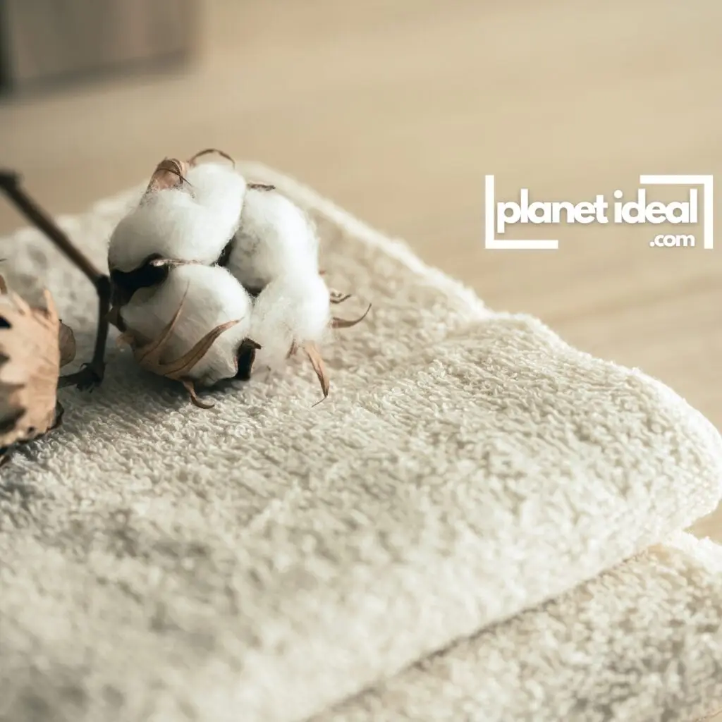 A neatly folded stack of organic cotton towels , arranged on a bathroom shelf.