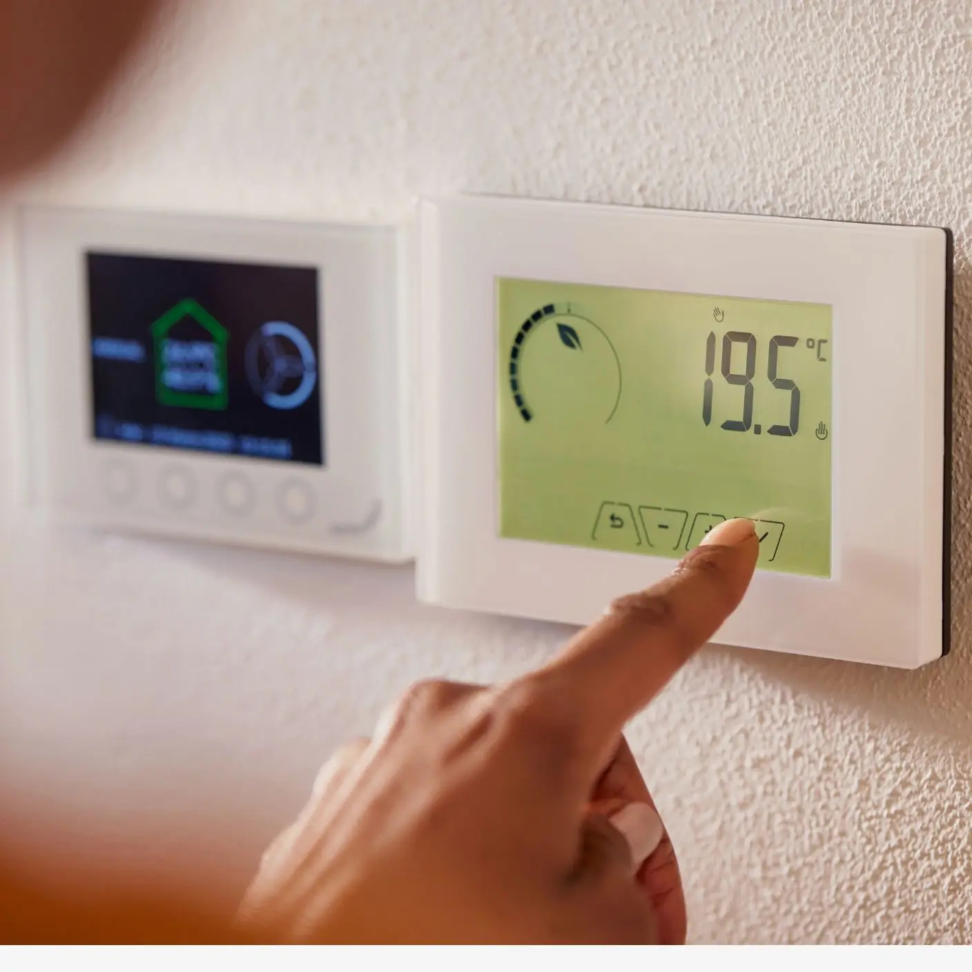 A smart thermostat mounted on a wall, displaying energy savings data