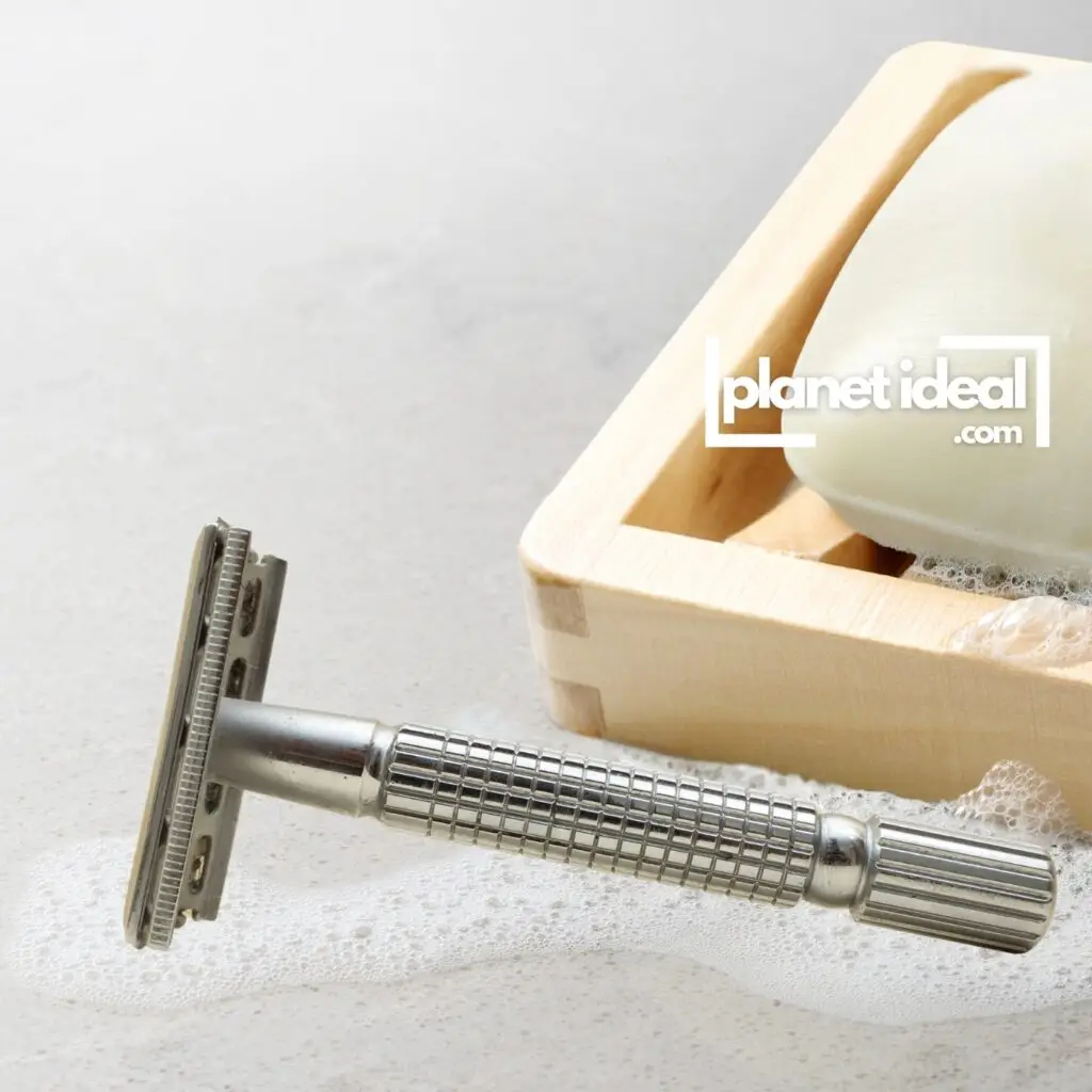 A stainless steel safety razor placed next to a bar of shaving soap on a bathroom counter.