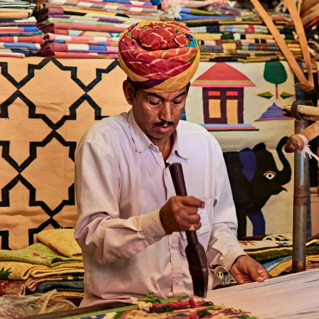A traveler interacting with a local artisan, learning traditional craft-making