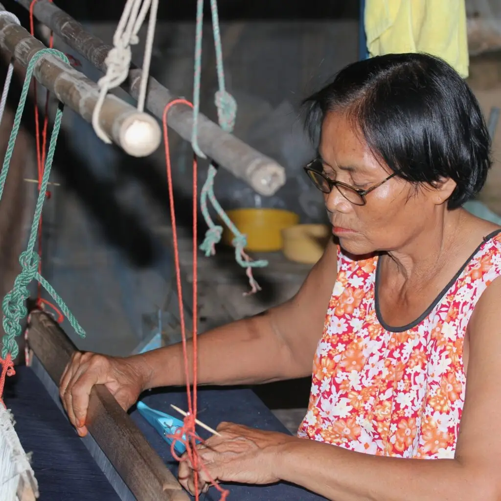 Artisan weaving fabrics by hand, showcasing traditional craftsmanship