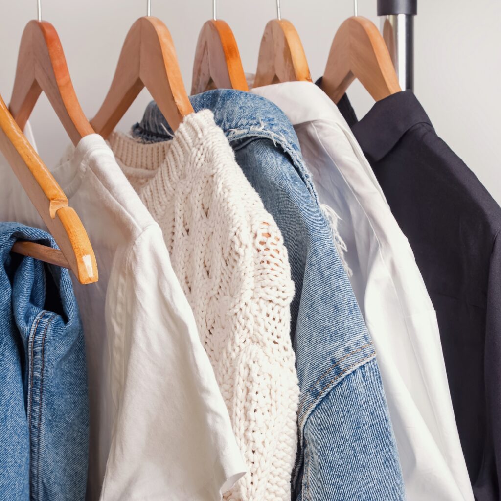 Minimalist Wardrobe with neutral basics neatly arranged like a white shirt tailored blazer jeans etc
