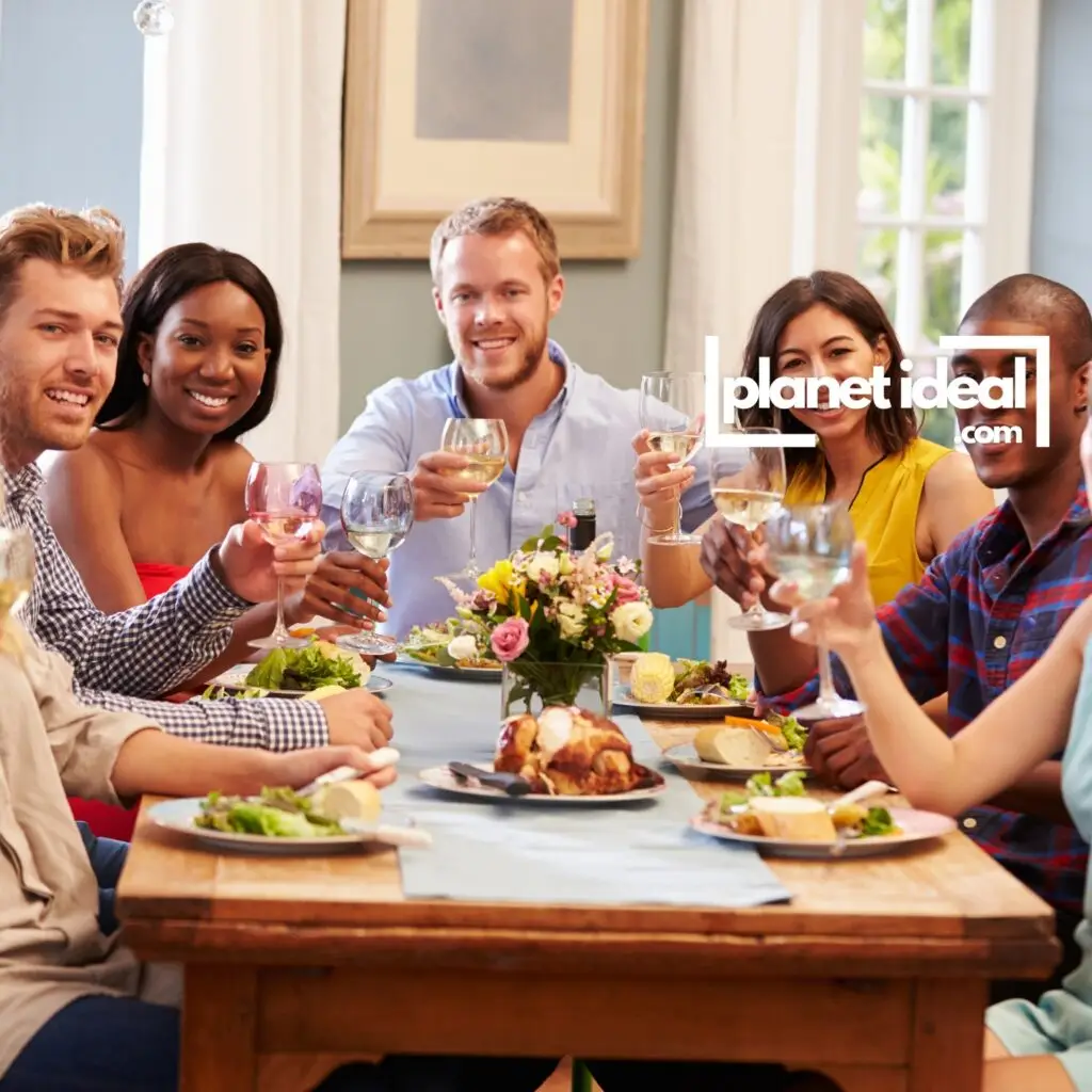 A group of friends sharing laughter around a table with home-cooked food.