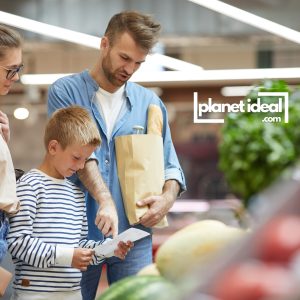 A family looking at a grocery list with colorful vegetables in the background.