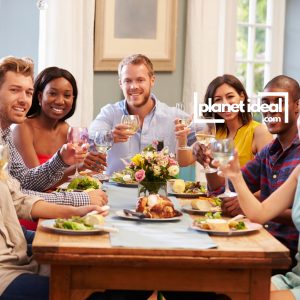 A group of friends sharing laughter around a table with home-cooked food.
