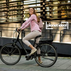 A rider cruising on an e-bike with a scenic city in the background.